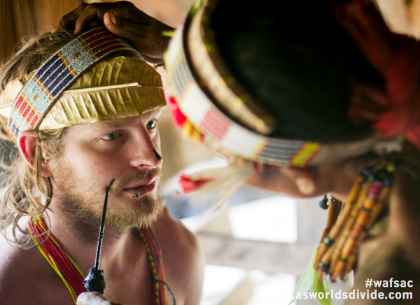 Australian tourist receiving custom face paint from Mentawai Sikerei during ceremony